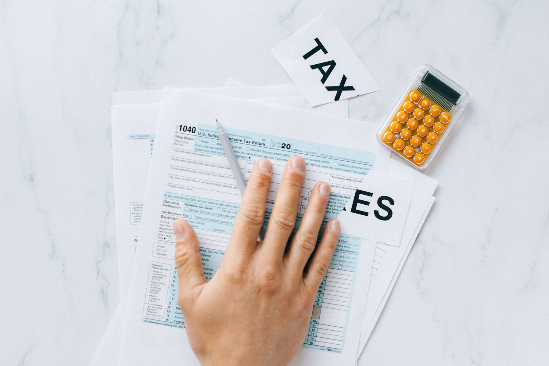 A small-business tax return being completed alongside a calculator